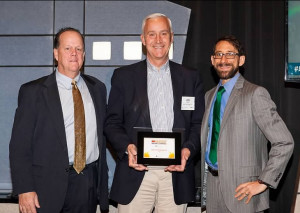 John Hayes, V.P., Sales holds the award, flanked by a rep from sponsor Dave Zinkler from Baker Tilly and LV Business publisher Michael O'Rourke